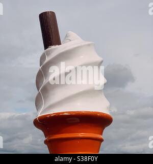 Ein überdimensionaler Kunststoff-Eiskegel am Strand Stockfoto