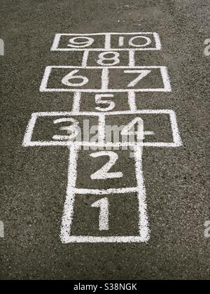 Zahlen eins bis zehn gemalt auf einem Spielplatz zu machen Das Spiel Hopscotch Stockfoto