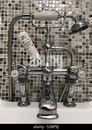 Retro-Stil Chrom Dusche und Bad Wasserhahn vor Mosaikwand. Stockfoto