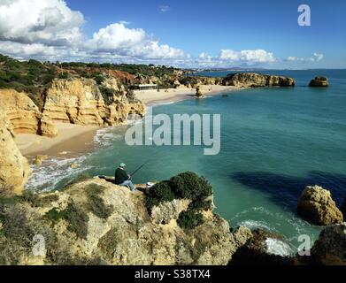 Ein Fischer am Strand Praia de São Rafael an der Algarve, Portugal Stockfoto