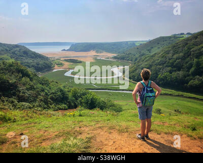 Frau mittleren Alters genießt den Blick über Pennard pill und Three Cliffs Bay von einem Pennard Castle, Gower, Swansea, Wales, August. Stockfoto