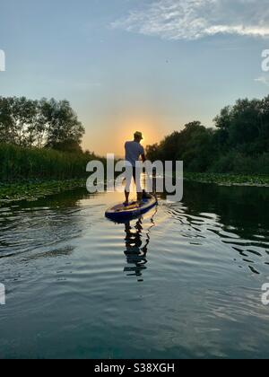Silhouette des Menschen auf Stand Up Paddle Board im Fluss In Montenegro Stockfoto