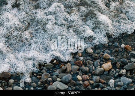 Wellen Sie sich an einem felsigen Strand Stockfoto