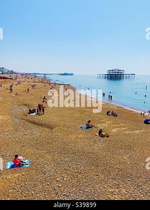 Brighton, Großbritannien - 11. August 2020: Blick auf West- und Palastpiers und den goldenen Strand. Sommerhitze 2020. Stockfoto