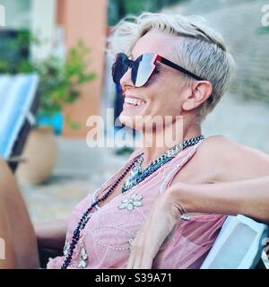 Seitenprofil der Frau in Sonnenbrille lächelnd Stockfoto