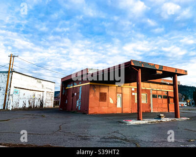 Verlassene Tankstelle und Garage in Nordkalifornien im frühen Morgenlicht unter blauem Himmel und weißen Wolken. Stockfoto