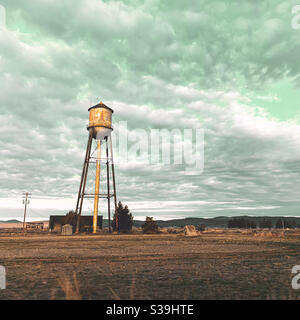 Wasserturm im frühen Morgenlicht unter einem bewölkten Himmel in Kalifornien. Quadratisches Erntegut. Stockfoto