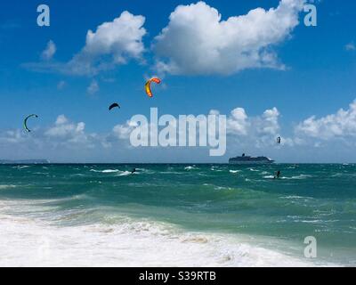 Kitesurfer und ein Kreuzfahrtschiff vor Bournemouth Beach mit Die Isle of Wight im Hintergrund Stockfoto