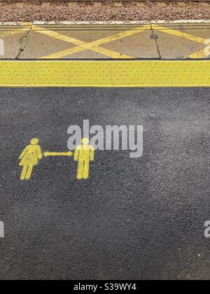 Soziale Distanzierungsschilder auf Bahnsteig in Großbritannien Stockfoto