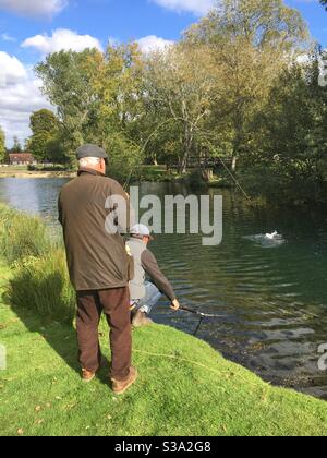 Fischer landen eine große Regenbogenforelle in Testwood Forellenfischerei, Hampshire, England, Vereinigtes Königreich. Stockfoto