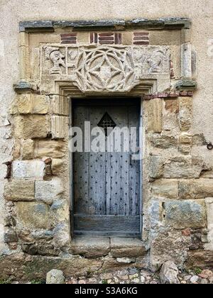 Geschnitzter mittelalterlicher Steinkopf zum Eingang in Saint-Benoit-du-Sault, Indre, Frankreich. Stockfoto