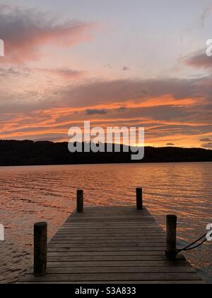 Sonnenuntergang über Lake Windermere, Lake District, Großbritannien. Zeigt einen Holzsteg. Stockfoto