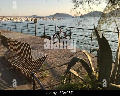 Blick von der Strandpromenade von Lerici auf den Golf der Dichter mit dem Hafen und dem Vorgebirge von Porto Venere im Hintergrund bei Sonnenuntergang, La Spezia, Ligurien, Italien Stockfoto