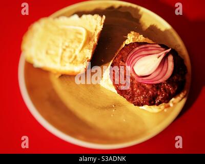 Rohe rote Zwiebel auf hausgemachtem Rindfleisch-Burger Stockfoto