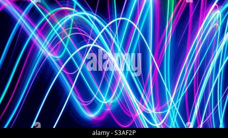 Eine lange Belichtung Licht Malerei Foto von mehrfarbigen Fee Lichter in einem atemberaubenden lebendigen abstrakten Hintergrund Muster Stockfoto