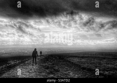 Zwei Personen gehen im Wind und Regen auf dem To Von Pendle Hill in Lancashire Stockfoto