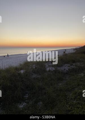 Obere Ansicht des späten Abendhimmels mit Leuten auf Florida Weißer Sandstrand Stockfoto