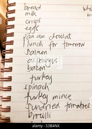 Einkaufsliste in einem spiralgebundenen Notizbuch. Stockfoto
