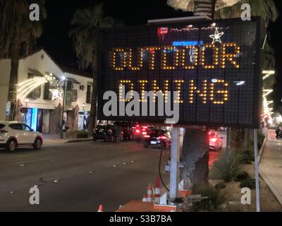 Palm Springs, USA. November 2020. Ein Restaurant im Freien Schild früh in der Nacht, als Flussufer Grafschaft zieht zurück in die lila Tier nach covid-19 Infektionen Spitze. Stockfoto