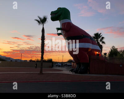 Palm Springs, USA. November 2020. Der Cabazon Dinosaurier verkleidet wie der Weihnachtsmann bei Sonnenuntergang direkt vor Palm Springs. Stockfoto