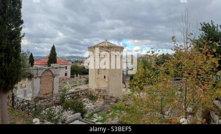 Der Turm der Winde, eine alte Wetterfahne und ein Uhrturm, steht inmitten der Ruinen der römischen Agora in Athen, Griechenland, unter einem bewölkten Himmel Stockfoto