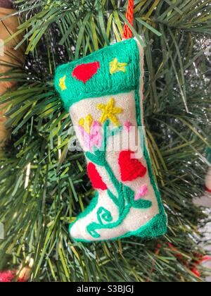 Ein handgefertigtes Weihnachtsornament, das an einem Baum hängt. Stockfoto