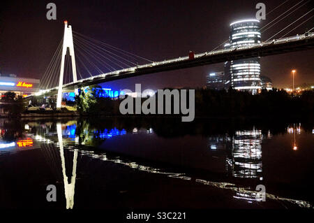 Blick auf die große Fußgängerbrücke über den Fluss und Seine Spiegelung im Wasser Stockfoto