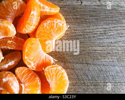 Geschälte satsuma, Orange, Clementine oder Mandarine auf einem hölzernen Hintergrund mit Kopierraum Stockfoto