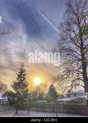 Eine helle untergehende Sonne in einer Winterlandschaft. Stockfoto