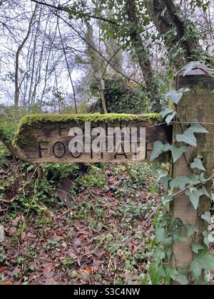 Altes Moos bedecktes Holzfußweg Schild mit Efeu bedeckt In einer Somerset Waldlandschaft Wanderroute Stockfoto