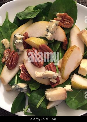 Ein Gourmet-Salat mit kandierten Pekannüssen, frischen Birnen und Stilton-Käse auf einem Spinatbett Stockfoto