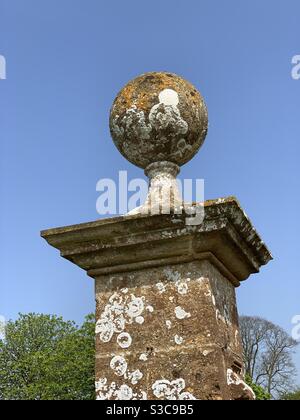 Eine atemberaubende Flechten-bedeckten Stein Ball Finial auf einer Torpfosten. Stockfoto