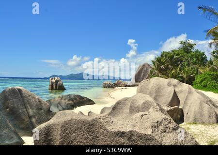 Große Granitfelsen sitzen auf dem weißen, reinen Sand und Strand der Luxusinsel La digue in der Archipel der Seychellen weiß türkis Indischen Ozean sanft massiert die Ufer Stockfoto