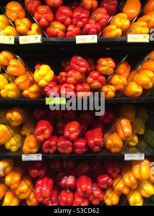 Rote und gelbe Paprika sind gestapelt und angezeigt I. der Supermarkt. Stockfoto