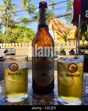 Bier laotische Biere und Flasche mit Tempel im Hintergrund Vientiane Laos Stockfoto