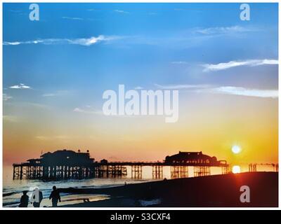 Menschen am Brighton Strand bei Sonnenuntergang. Stockfoto