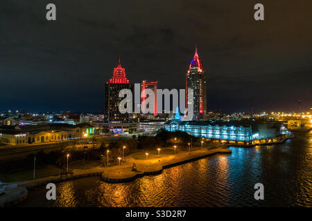 Die Skyline von Downtown Mobile, Alabama am Wasser bei Nacht Stockfoto