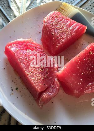 Nahaufnahme von rohen frischen, gewürzten Thunfisch-Steaks auf einem Platte Stockfoto