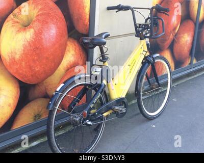 Yellow YoBike Leihrad vor einem Geschäft mit großen Obstbildern in den Fenstern, in Bristol, England, Großbritannien Stockfoto