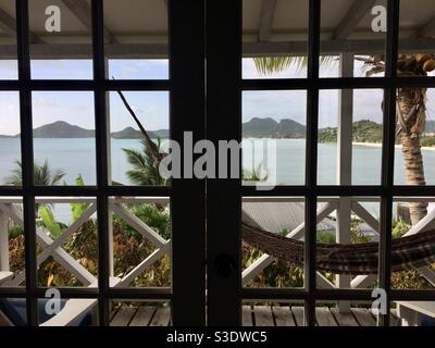 Der Meerblick von einem Hotelzimmer im Coco Bay Resort, Antigua auf einen Balkon mit einer gestreifte Stoffhängematte. Stockfoto