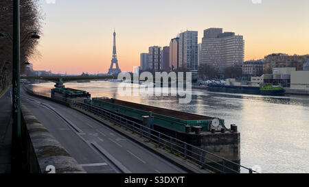 Paris, Frankreich. März 07. 2021. Modernes Gebäude im Stadtteil Beaugrenelle. Historisches Denkmal, Eiffelturm im Hintergrund. Die seine im Vordergrund mit Barge. Stockfoto