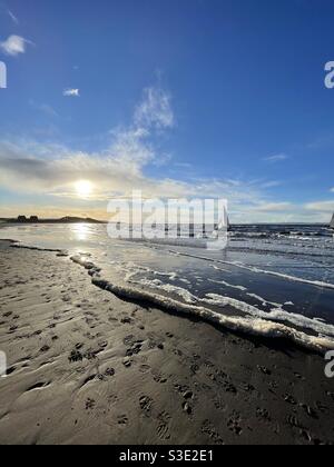 Wunderschöne malerische Aussicht auf den Sonnenuntergang über dem Meer von Prestwick Beach, Ayrshire, Schottland auf Firth of Clyde, Westküste mit einer einzigen Yacht im Meer. Stockfoto