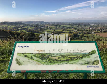 Blick vom Coaley Peak, in den Cotswolds, in der Nähe von Stroud, Gloucestershire, England. Blick nach Westen in Richtung des Flusses Severn und darüber hinaus nach Wales. Das Hinweisschild zeigt die Sehenswürdigkeiten in der Ansicht an Stockfoto