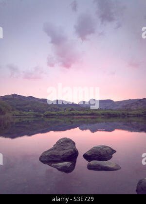 Morgenlicht über den Langdale Pikes von Loughrigg Tarn, Lake District, Großbritannien Stockfoto