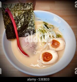 Authentische japanische Tonkotsu-Ramen-Schüssel mit Hanjuku Tamago (weich gekochtes Ei), Chasyu (geschmorter Schweinebauch) und Nori (getrocknete Algen) Stockfoto