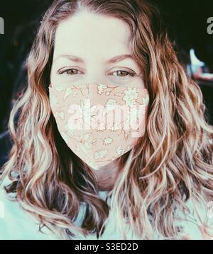 Frau trägt eine Maske und lächelt. Stockfoto