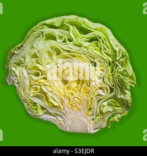 Eisbergsalat in Scheiben auf hellgrünem Hintergrund. Bio-Salat. Knusprige, frische Produkte Stockfoto