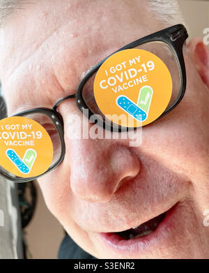 Ein älterer Mann mit mir hat meine Covid-Brille mit Stickern versehen, um zu feiern, dass sie geimpft wurde, NYC, USA, 2021 Stockfoto