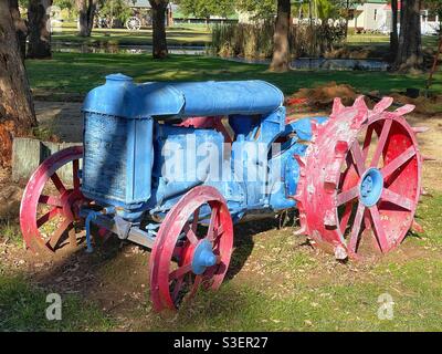 Alter Traktor, blau lackiert mit roten Rädern im Pioneer Village in Inverell, New South Wales, Australien Stockfoto