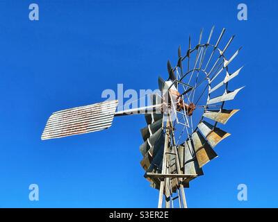 Historische Metallwindmühle vor klarem blauen Himmel im Pioneer Village in Inverell, New South Wales, Australien Stockfoto